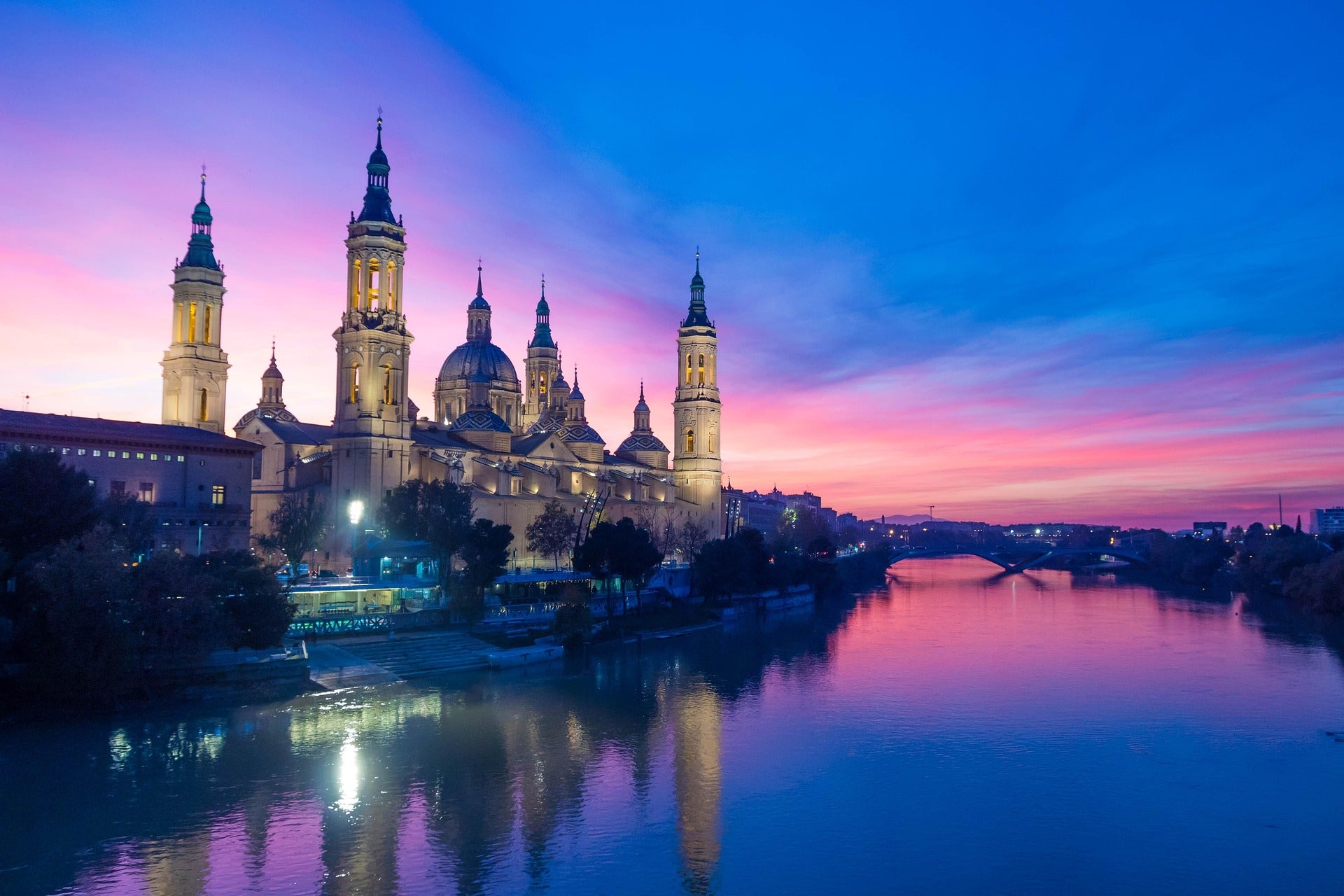 Vista de Zaragoza al anochecer, destacando su papel como centro logístico con alta demanda de merchandising para industrias y eventos B2B.